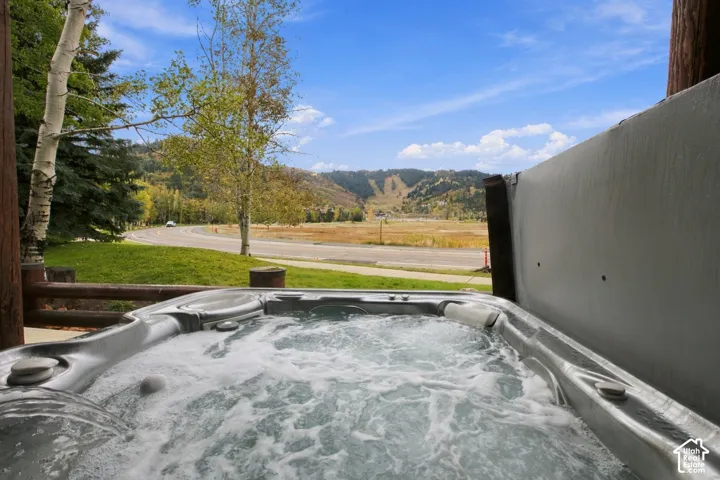 Outdoor spa with bubbling water, accompanied by a mountain and valley backdrop