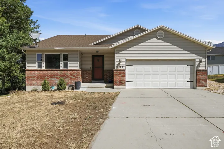 Exterior featuring brick and siding facade, an attached two-car garage, and a concrete driveway