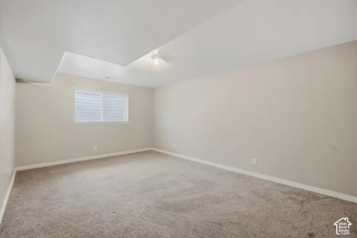 Carpeted flooring with light-toned walls and a window