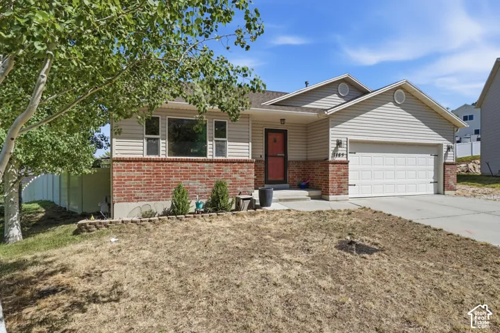 Brick and siding exterior with an attached two-car garage, concrete driveway, and covered entry porch