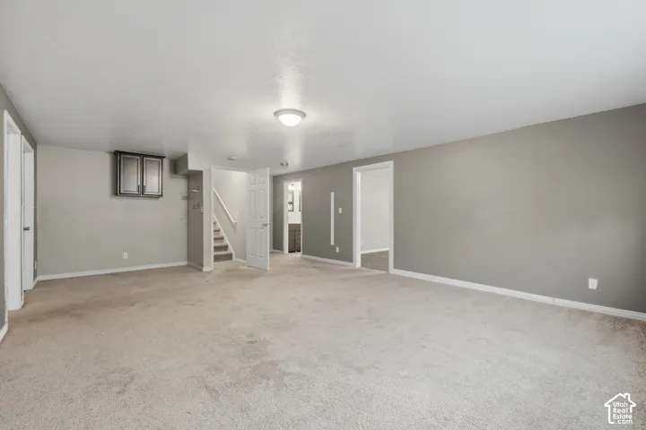 Spacious room with gray wall paint and light-toned carpeting