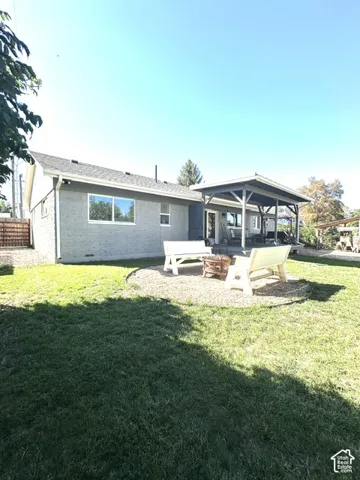 Expansive rear yard featuring a gravel patio area with a built-in fire pit