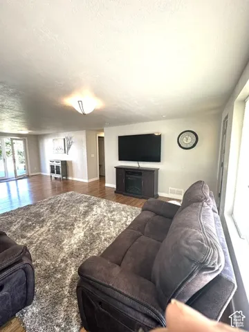 Hardwood-finish flooring throughout, recessed lighting, and an entertainment console with an integrated electric fireplace