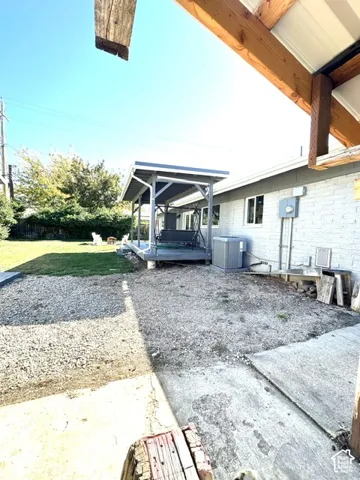 Gravel and concrete patio areas, covered outdoor structure, and a manicured lawn