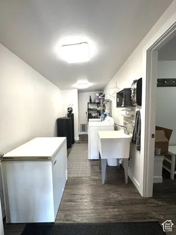 Laundry room featuring wood-finish flooring, a utility sink, and recessed lighting