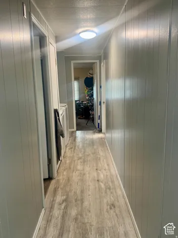Wood-finish flooring, paneled walls, and a flush mount ceiling light