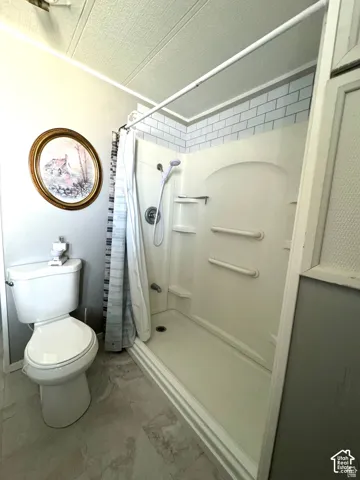 White subway tile shower surround with integrated shelving and grab bar