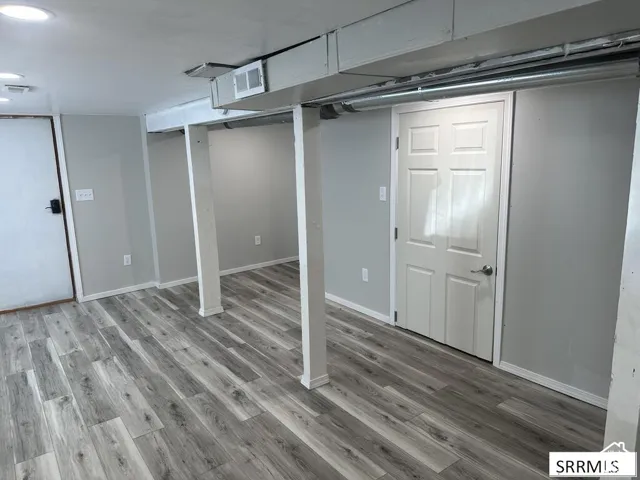 Wood-finish flooring with light gray walls, white trim, and recessed lighting