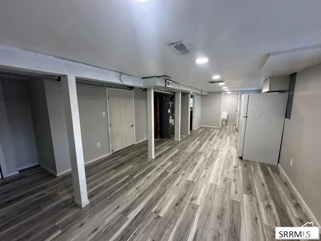 Expansive room with wood-finish flooring, recessed lighting, and light gray walls