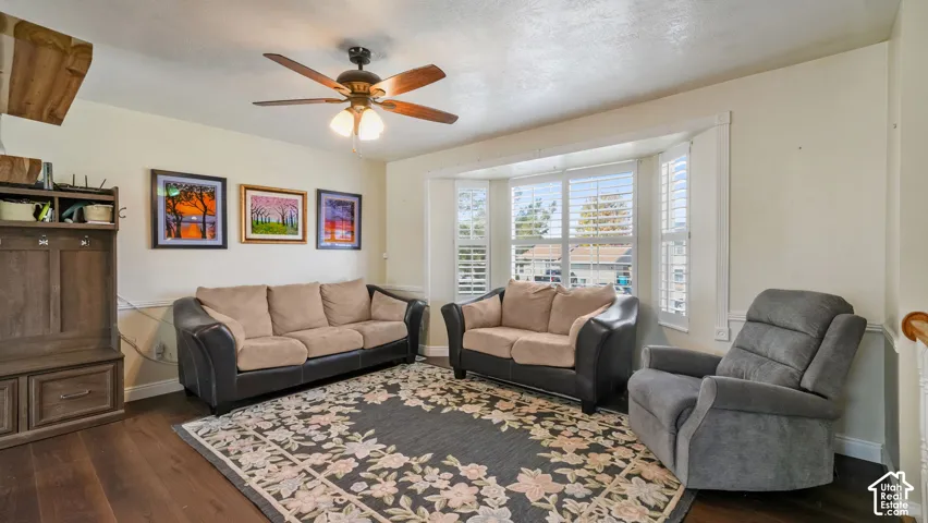 Wood-finish flooring, ceiling fan with integrated lighting, bay window with plantation shutters, built-in storage unit