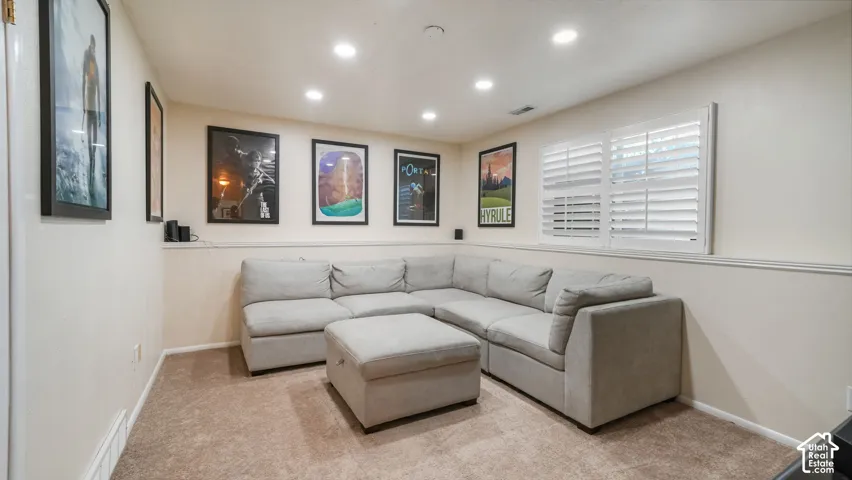 Recessed lighting, neutral wall tones, white plantation shutters, carpeted flooring, and a chair rail molding