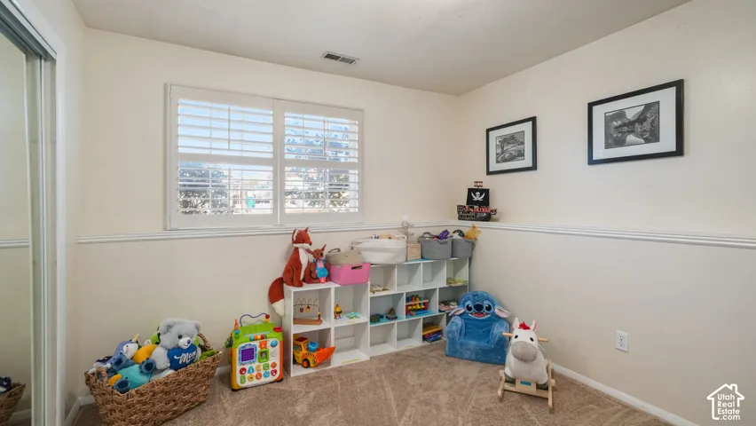 Window with white plantation shutters, neutral tone walls, and wall molding