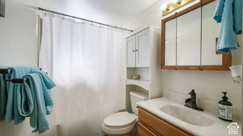 Bathroom featuring a vanity with a white countertop, wood-finish cabinetry, built-in medicine cabinet, and an overhead lighting fixture