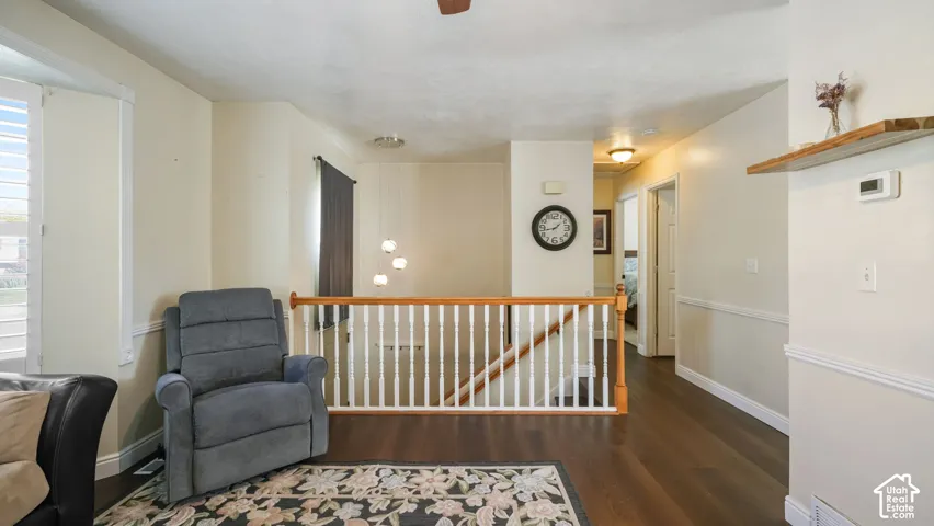 Hardwood-finish flooring, white spindle railing with wood top rail, recessed lighting, and white baseboards