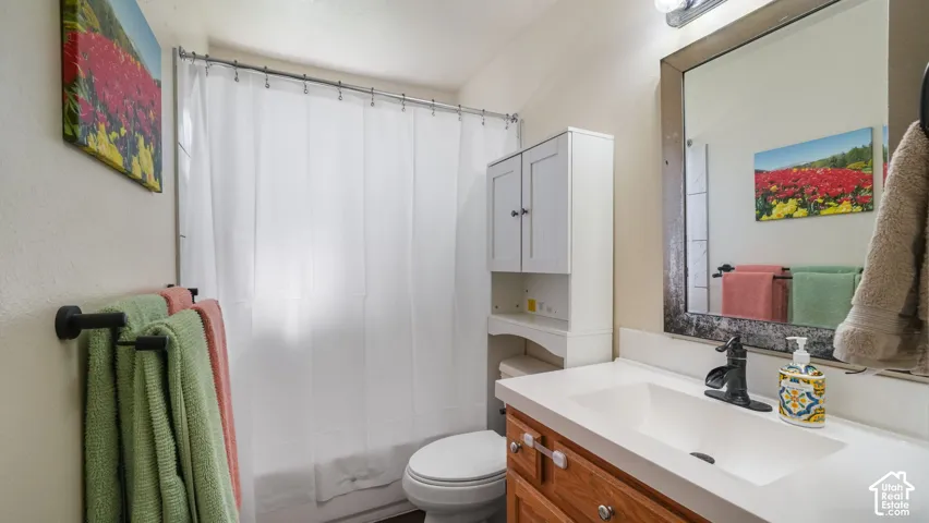 Vanity with integrated sink, wood-finish cabinetry, and dark-toned faucet