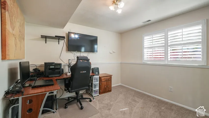 Recessed ceiling light fixture, two windows with white louvered shutters, neutral carpeting, and a chair rail molding