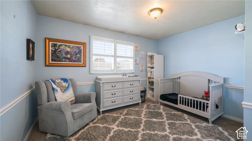 Recessed ceiling light fixture, wall-mounted picture rail molding, and window with white plantation shutters