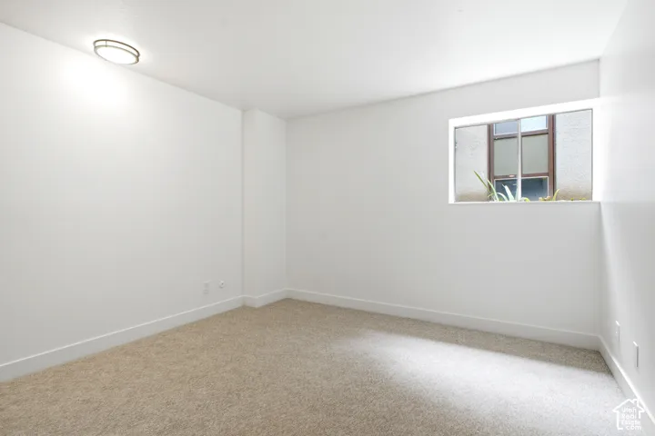 Carpeted flooring, recessed window, flush-mount ceiling light fixture, and white wall finishes