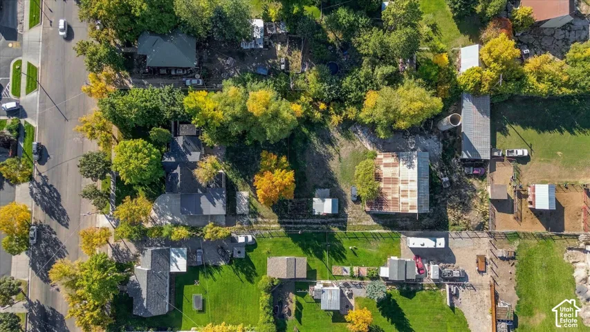 Aerial perspective highlighting multiple structures, mature trees, and expansive land