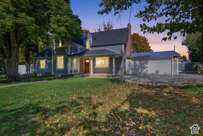 Two-story residence with a covered front porch, a multi-pane front door, and a detached two-car garage with a metal roof