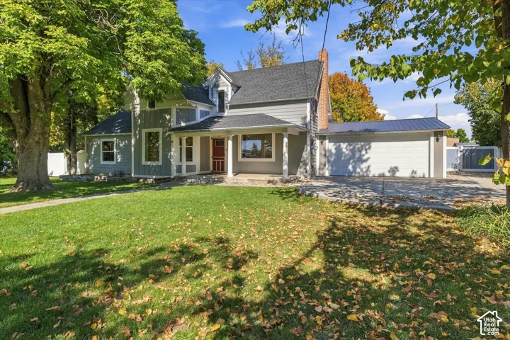 Charming farmhouse-style residence featuring a classic front-entry design with a covered porch, multi-pane windows, and a distinctive cupola