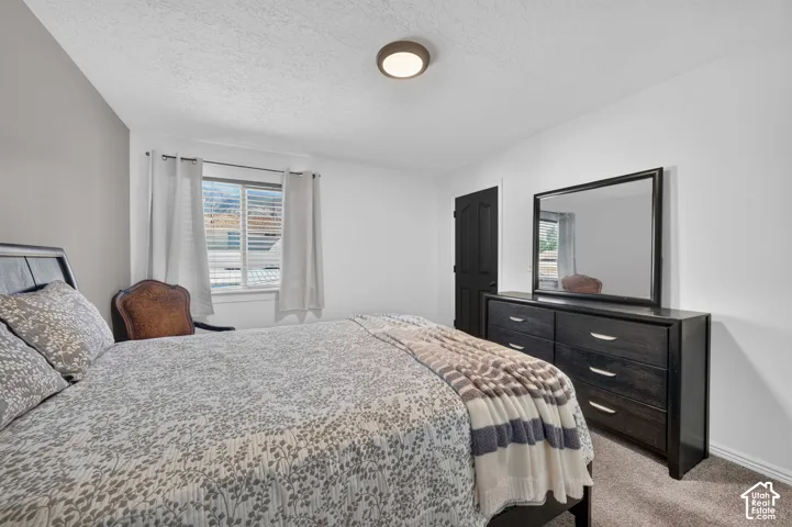 Recessed window with horizontal blinds, flush mount ceiling lighting, and textured carpeting