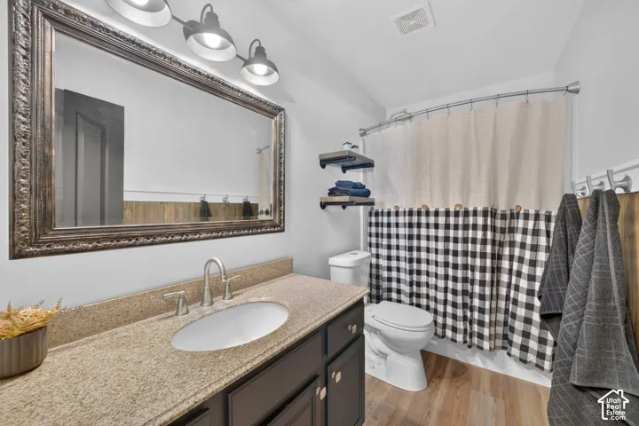 Granite-finish countertop, undermount sink, wood-finish flooring, and built-in shelving