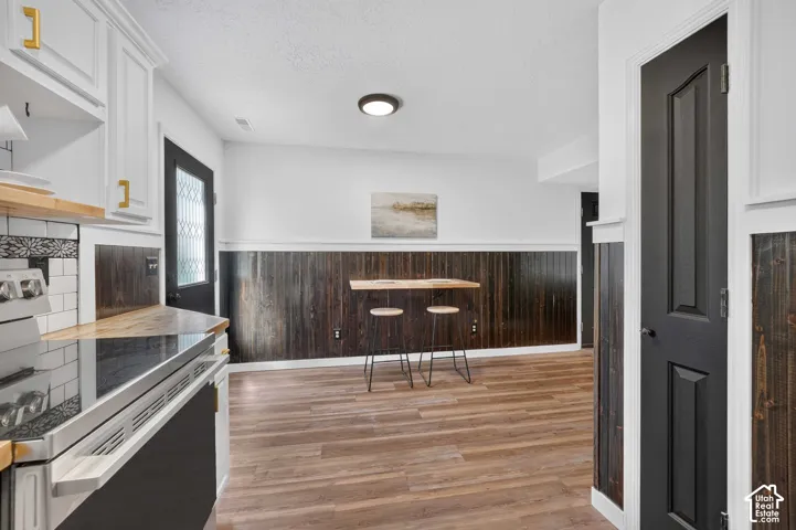 Wood-finish flooring throughout, complemented by dark wood paneling and white trim