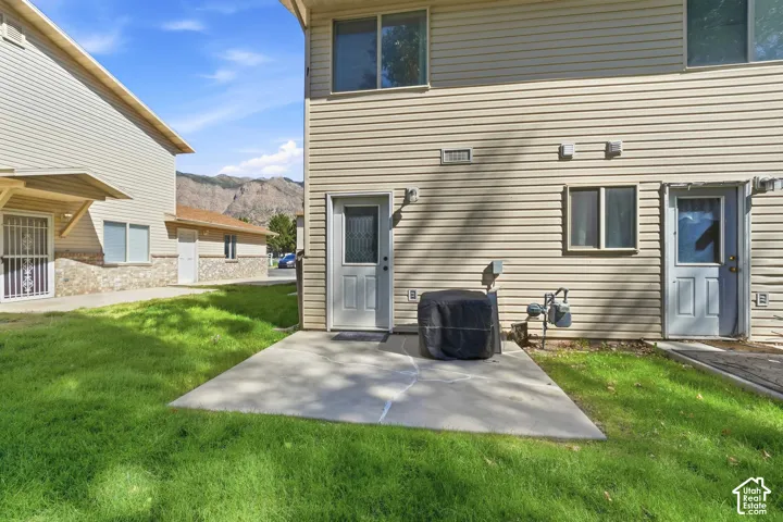 Private concrete patio with a grassy area