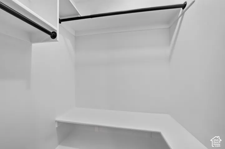 Built-in white shelving, integrated hanging rods, and clean white walls