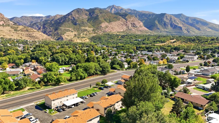 Expansive mountain backdrop, established neighborhood setting, mature trees, multi-lane roadway access, and covered parking structures