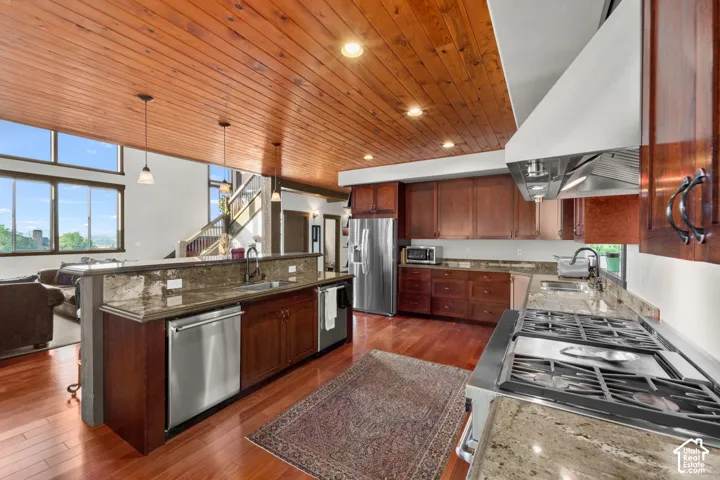 Kitchen featuring wood-finish flooring, wood cabinetry, stone countertops, stainless steel appliances, and a wood plank ceiling