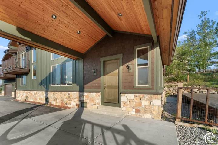 Covered entry with wood-finish ceiling, recessed lighting, and stone veneer foundation