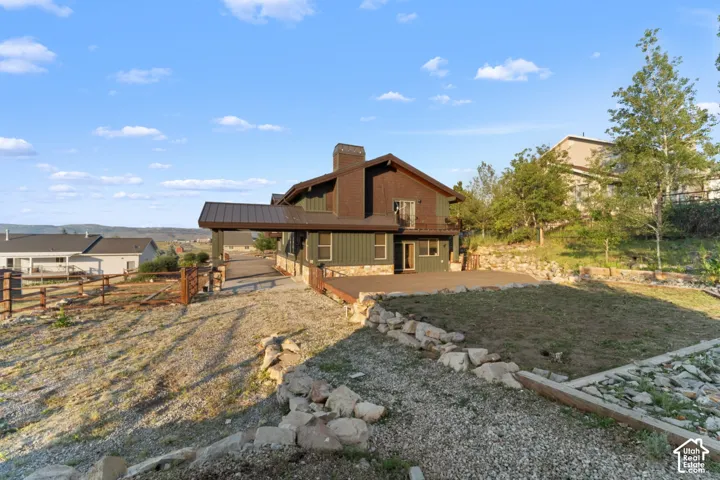 Multi-level exterior with a gable roof, covered patio, and attached balcony