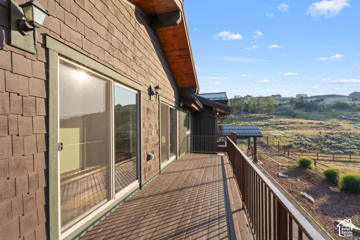 Expansive outdoor deck with durable wood-finish planks, multiple sliding glass doors, and a decorative railing