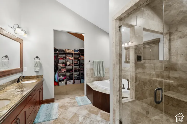 Double vanity with undermount sinks, stone countertop, and dark wood-finish cabinetry