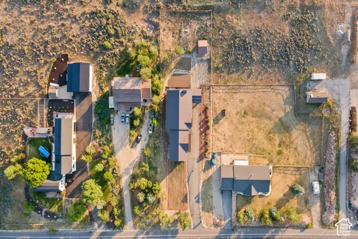 Expansive property featuring multiple structures, paved driveways, and natural landscaping