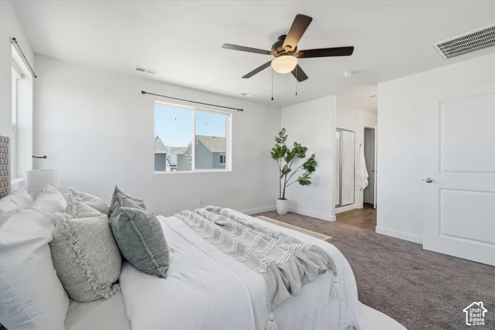 Recessed lighting, ceiling fan, carpeted flooring, and a sliding glass shower enclosure