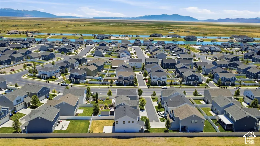 Residential neighborhood featuring detached homes with varied exterior colors, paved streets, and green landscaping