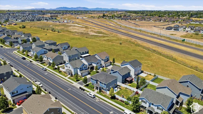 Residential neighborhood featuring single-family homes with pitched roofs, front-facing garages, and fenced backyards