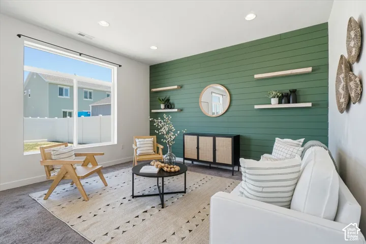 Expansive window, recessed lighting, accent wall with shiplap detailing, built-in shelving, and carpet flooring