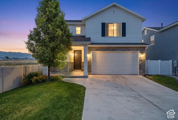 Two-story residence featuring light-colored siding and stone veneer accents