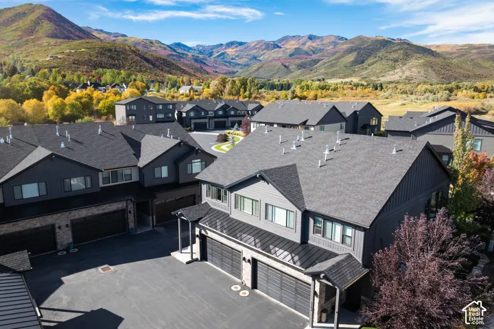 Townhome community featuring modern exteriors, mountain backdrop, and multiple attached garages