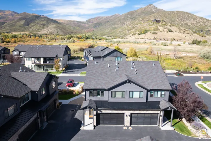 Modern architectural style with dark siding, attached two-car garage, and a covered entry