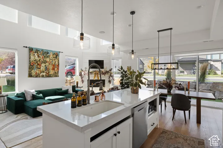 Gourmet kitchen island with an integrated sink, white cabinetry, and quartz countertops