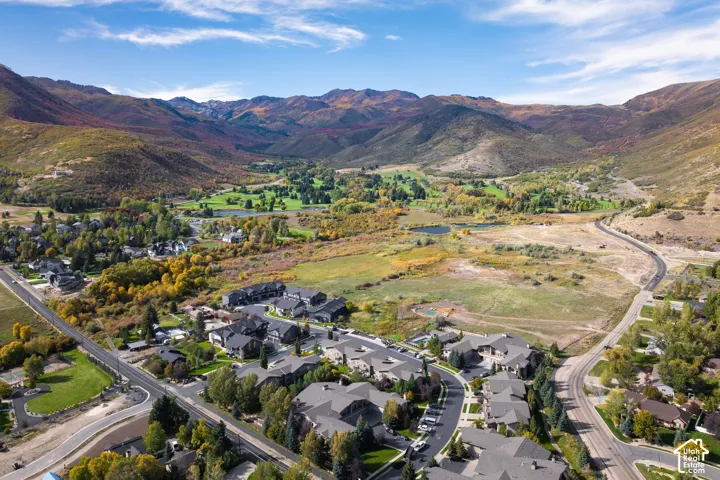 Mountainous terrain, residential properties, paved roads, and green spaces