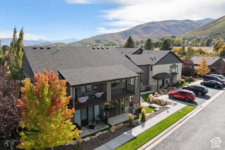 Modern townhome exterior with dark gray siding, light-colored stucco accents, and a covered entryway
