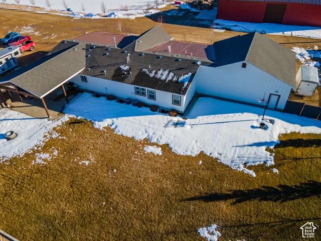 Single-story residence with a covered patio, multiple rooflines, a distinct red barn structure, and surrounding open land