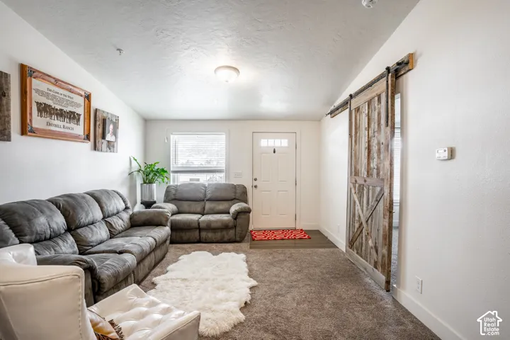 Spacious recreation room featuring comfortable seating arrangements, carpeted flooring, and abundant natural light from multiple windows