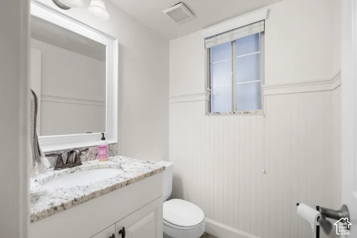 White vanity with a granite countertop and an undermount sink
